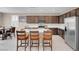Kitchen with stainless steel appliances, white countertops, dark cabinetry, and seating at the island at 3556 Valley Lily St, North Las Vegas, NV 89032