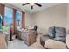 Bright home office with a ceiling fan, a large window, and a comfortable recliner chair at 3556 Valley Lily St, North Las Vegas, NV 89032