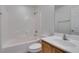 Well-lit bathroom featuring a shower-tub combo with white tiled walls and oak sink vanity at 3774 Dusky Flycatcher St, Las Vegas, NV 89122