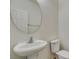 Powder room with a pedestal sink, circular mirror, and neutral color scheme at 3774 Dusky Flycatcher St, Las Vegas, NV 89122