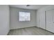 Bright bedroom features sleek gray wood-look floors, window with blinds, and double-door closet at 3774 Dusky Flycatcher St, Las Vegas, NV 89122