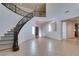 Open foyer with a striking curved staircase and neutral tile floors at 3774 Dusky Flycatcher St, Las Vegas, NV 89122