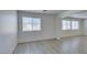Bright living room with large windows offering natural light, with sleek gray wood-look floors at 3774 Dusky Flycatcher St, Las Vegas, NV 89122