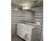 Bathroom featuring a white vanity with a marble countertop and large mirror, complemented by stylish gray-striped tile walls at 3831 Atlantis St, Las Vegas, NV 89121