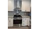 Stainless steel range oven with white cabinets and subway tile backsplash at 3831 Atlantis St, Las Vegas, NV 89121