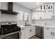 Bright kitchen features white cabinets, stainless steel appliances, and a modern black range hood at 4450 San Rafael Ave, Las Vegas, NV 89120