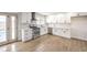 A modern kitchen featuring white cabinetry, stainless steel appliances, and light wood floors at 4450 San Rafael Ave, Las Vegas, NV 89120