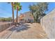 Spacious backyard with gravel and palm trees, partially fenced and ready for personalization at 4548 Switchback St, North Las Vegas, NV 89031