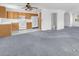 Open concept kitchen and living area with carpet, tile flooring, and a view into the half bathroom at 4548 Switchback St, North Las Vegas, NV 89031