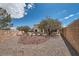 Backyard featuring gravel landscaping, small trees, a privacy wall, and blue skies at 4804 Laurentia Ave, Las Vegas, NV 89141