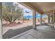 Covered patio with low-maintenance gravel landscaping, mature trees, and privacy wall at 4804 Laurentia Ave, Las Vegas, NV 89141