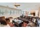 Open concept living room with ceiling fan, plantation shutters, and leather furniture at 4804 Laurentia Ave, Las Vegas, NV 89141