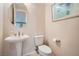 Classic powder room with pedestal sink, round mirror, and neutral wall color at 4804 Laurentia Ave, Las Vegas, NV 89141