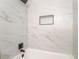 Modern bathroom shower featuring black fixtures, white marble tile, and convenient recessed shelving at 50 Armstrong Cir, Henderson, NV 89015