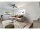 Bright living room featuring a stylish couch, ceiling fan, and large windows allowing natural light at 50 Armstrong Cir, Henderson, NV 89015