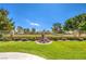 Green backyard featuring manicured lawn, brick retaining wall and tranquil water feature at 5000 Linkside Dr, Las Vegas, NV 89130