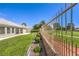 Expansive backyard featuring lush green grass, a view of the golf course, and mature trees beyond the fence at 5000 Linkside Dr, Las Vegas, NV 89130