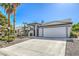 Front exterior showcasing a two-car garage, landscaped front yard, and covered entry at 5000 Linkside Dr, Las Vegas, NV 89130