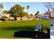 View of golfers playing on a green in the golf course with palm trees and residential homes at 5000 Linkside Dr, Las Vegas, NV 89130