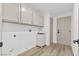 Well-organized laundry room with modern cabinets, sleek fixtures, and wood-look flooring for added appeal at 5000 Linkside Dr, Las Vegas, NV 89130