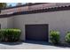 Garage exterior with dark brown door, landscaping, and house number above at 5250 S Rainbow Blvd # 2106, Las Vegas, NV 89118