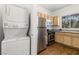 Compact kitchen area with stacked washer/dryer and stainless steel appliances at 5250 S Rainbow Blvd # 2106, Las Vegas, NV 89118