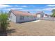 Back of the house with stucco siding, gravel and tile roof, and small concrete patio at 540 Kelsford Dr, Las Vegas, NV 89123