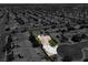 Aerial view of a home, singled out in color, with a desert landscaped yard and pool surrounded by grayscale houses at 6032 Red Glitter St, North Las Vegas, NV 89031