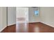 Bright bedroom features neutral paint, hardwood floors, and an open doorway leading to a larger room at 6032 Red Glitter St, North Las Vegas, NV 89031
