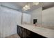 Bright bathroom features a single sink with a light-colored countertop and white shower curtain at 6056 Atlantis Dream Ave, Las Vegas, NV 89139
