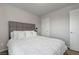 Clean bedroom showcasing a bed with white comforter, next to a white door leading out of the room at 6056 Atlantis Dream Ave, Las Vegas, NV 89139