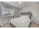 Neutral bedroom featuring a window with blinds and a bed with a gray headboard and white bedding at 6056 Atlantis Dream Ave, Las Vegas, NV 89139