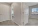 Bright hallway with a window, doorway to a bedroom, and neutral carpeted floors at 6056 Atlantis Dream Ave, Las Vegas, NV 89139