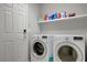 Clean laundry room featuring a front-load washer and dryer next to a door and shelving at 6056 Atlantis Dream Ave, Las Vegas, NV 89139