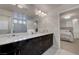 Elegant bathroom featuring double sinks, marble countertops, and a view to the main bedroom at 6056 Atlantis Dream Ave, Las Vegas, NV 89139