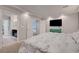 Spacious bedroom with neutral tones, a large bed, a TV, and an adjoining bathroom at 6056 Atlantis Dream Ave, Las Vegas, NV 89139