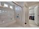 Modern shower with marble tiles and a glass door, adjoining a walk-in closet at 6056 Atlantis Dream Ave, Las Vegas, NV 89139