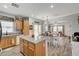 Open concept kitchen featuring an island, wood cabinets, granite countertops, and wood-look floors at 6271 Sunset Spring Ave, Las Vegas, NV 89122