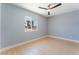 Bedroom with wood-look floors, modern fan, and view of mature trees at 6324 Eugene Ave, Las Vegas, NV 89108