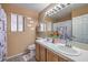 Bathroom with double sink vanity, tile floors, decorative mirror and natural lighting at 6408 Deadwood Rd, Las Vegas, NV 89108