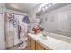 Bathroom with a white vanity, tile counter, and decorative shower curtain at 6408 Deadwood Rd, Las Vegas, NV 89108