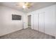 Bright bedroom with carpet, ceiling fan, and TV; doorway to bathroom can be seen at 6408 Deadwood Rd, Las Vegas, NV 89108