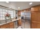 Eat in kitchen with stainless steel refrigerator, granite counters, and large window at 6408 Deadwood Rd, Las Vegas, NV 89108