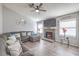 Cozy living room featuring a stone fireplace, plush sectional couch, and two bright windows at 6408 Deadwood Rd, Las Vegas, NV 89108