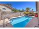 Sparkling pool with blue tile, lush landscaping, and shaded lounge area offers ultimate relaxation at 6408 Deadwood Rd, Las Vegas, NV 89108