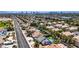 Residential neighborhood featuring houses, landscaping, swimming pools, and putting green, set against a distant city skyline at 6773 Obannon Dr, Las Vegas, NV 89146