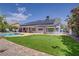 Backyard showcasing a putting green, lush lawn, sparkling pool, and home's rear elevation with solar panels at 6773 Obannon Dr, Las Vegas, NV 89146