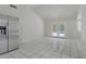 Spacious kitchen featuring white tile flooring and stainless refrigerator at 6773 Obannon Dr, Las Vegas, NV 89146