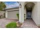 Inviting front entrance features an arched doorway, brick walkway, and attached two-car garage at 7052 Blissful Peak St, North Las Vegas, NV 89084