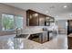 Stylish kitchen with granite countertops, dark wood cabinetry, and stainless steel appliances offers a functional and aesthetic space at 7052 Blissful Peak St, North Las Vegas, NV 89084